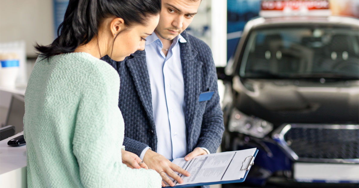 salesman presenting new car to clients in the background of dealership, salesman presenting new car to clients in the background of dealership