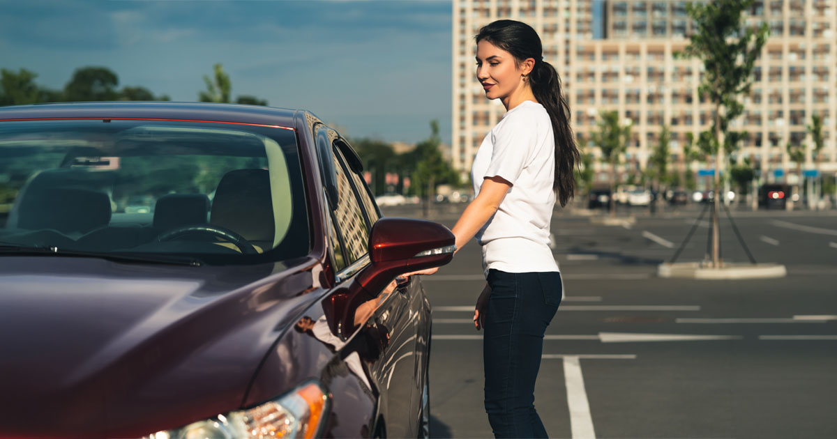 The woman stands near the new car on the parking, The woman stands near the new car on the parking